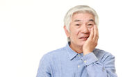 歯を抑える男性